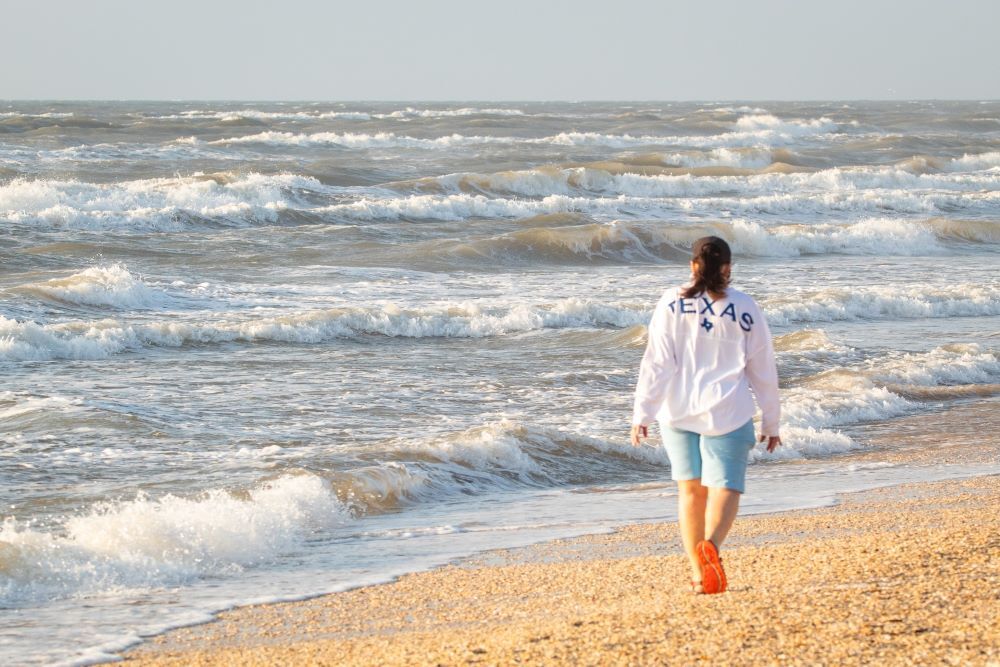 woman walking along seashore