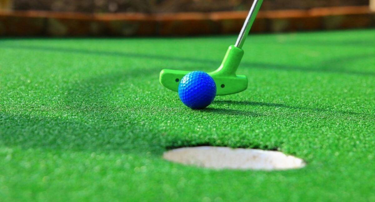 upclose of mini golf club and ball on course